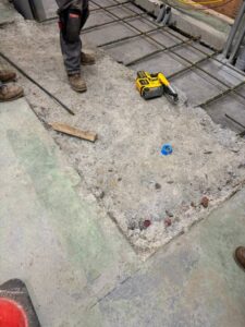 Rebar reinforcement installed during concrete slab repair for epoxy flooring