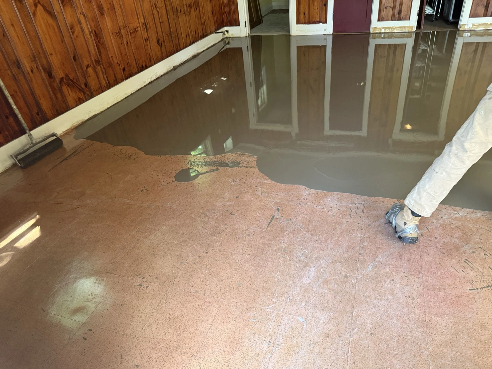 Self-leveling underlayment being installed on commercial concrete floor
